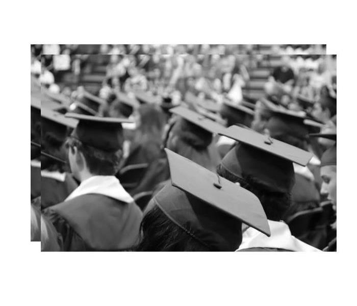this picture shows a group of young med and women seated from the back wearing graduation caps and gowns