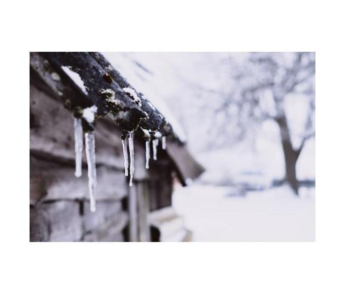 Icicles hanging off a home in snowy weather.
